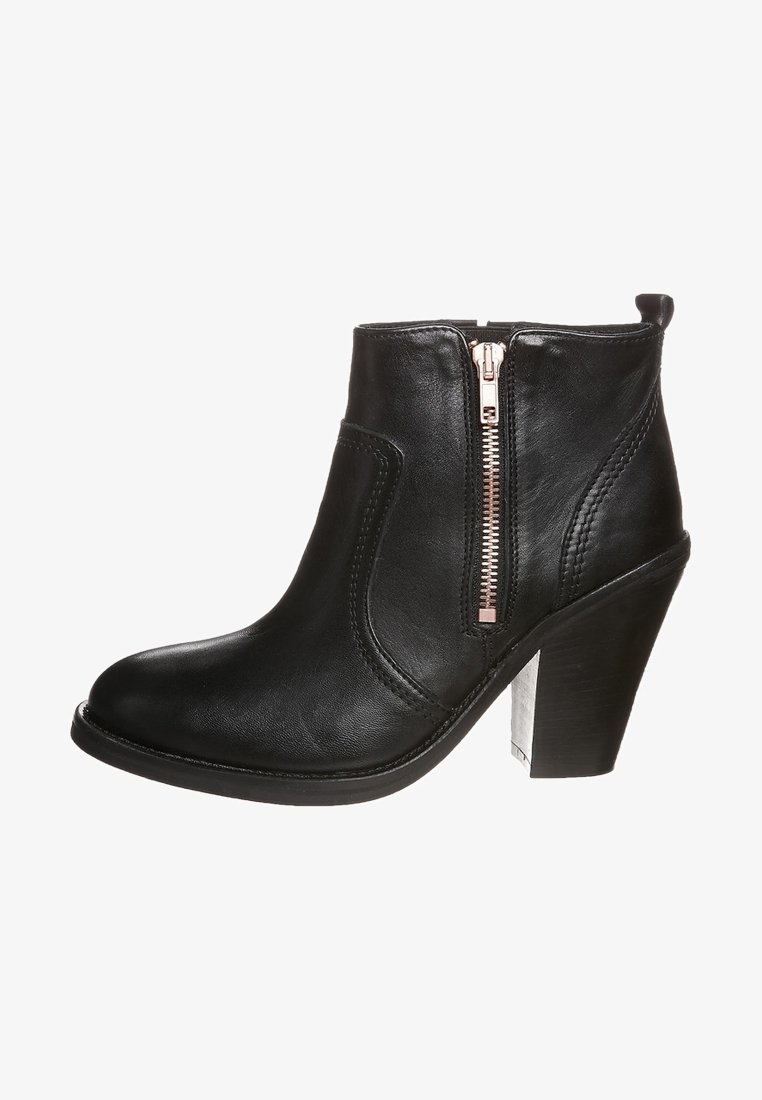 Svart läderankelboot med en sidodragkedja, rund tå och klack med staplade nivåer. Har sömdetaljer och en texturerad sula.