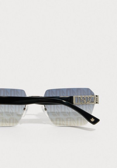 Gafas de sol negras cuadradas con lentes de gradiente que presentan un sutil patrón de logo. Detalles en plata y marca en la patilla.