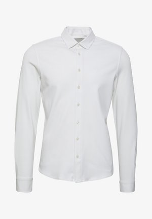 Bijela košulja s dugim rukavima i dugmadi napravljena od glatkog materijala, sa klasičnim ovratnikom, prednjom zaklopkom s dugmadi i uskim manžetnama.
