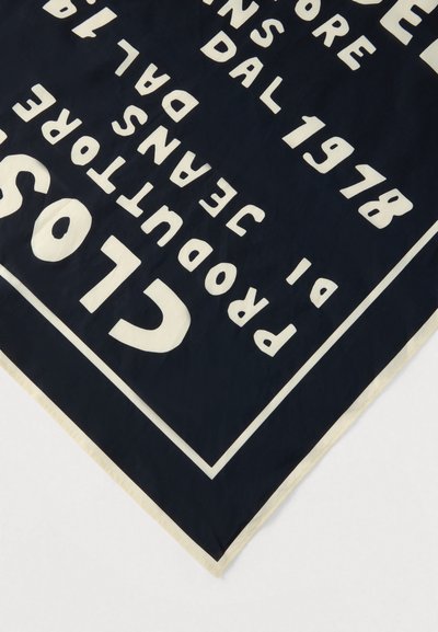 Μαύρο ύφασμα με έντονο λευκό κείμενο που αναγράφει "CLOS" και μερικές λέξεις όπως "PRODUITORS" και "JEAN'S DAL" μέσα σε σχεδιασμό με λευκό περίγραμμα.