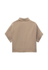 Lyhythihainen cropped-paita beigen värissä, jossa on klassinen kaulus, pehmeä rakenne ja rento istuvuus siisteillä saumoilla.