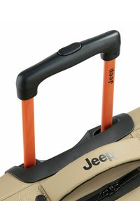 Equipaje beige con un mango negro y varillas retráctiles naranjas. Presenta un cierre y un logo negro en el frente. Textura suave.