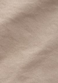 Beige katoenen stof met een fijne geweven textuur, zichtbaar lichte kreuken en een zachte, natuurlijke afwerking over het oppervlak.