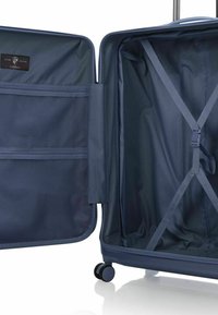 Navyblauer Hartschalenkoffer mit einem Reißverschlussfach, einem Netzfach und elastischen Gurten im Inneren zur Sicherung des Inhalts. Glatte Räder sichtbar.