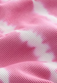 Różowo-biały materiał w paski o żebrowanej fakturze. Wzór charakteryzuje się delikatnymi nadrukami tie-dye w różnych odcieniach różu.