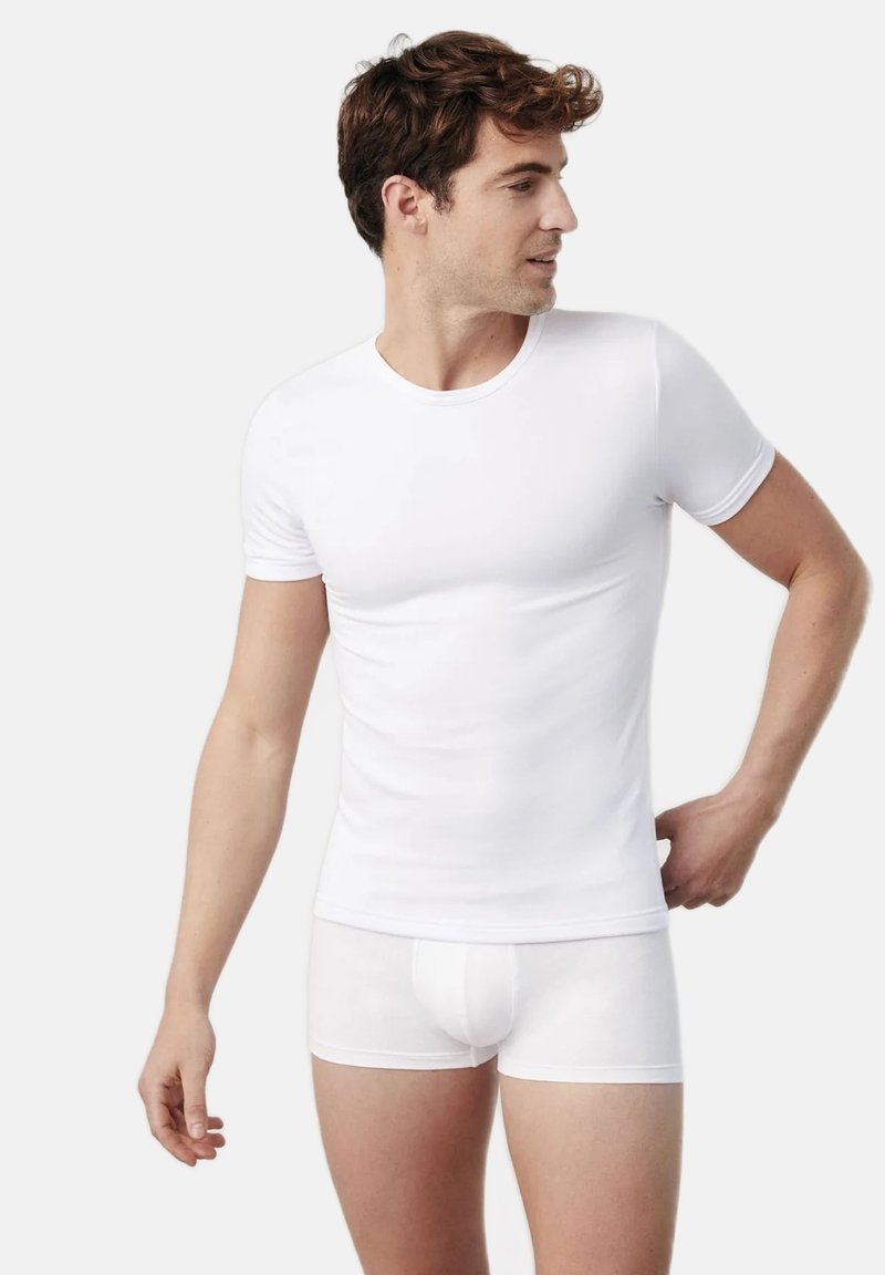 Camiseta blanca ajustada y bóxers blancos, hechos de una tela suave, con un cuello redondo clásico y mangas cortas.
