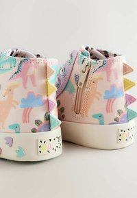 Sneaker alte con un motivo di dinosauri pastello, accenti zigzag colorati, una zip laterale e una suola in gomma bianca con dettagli stampati.