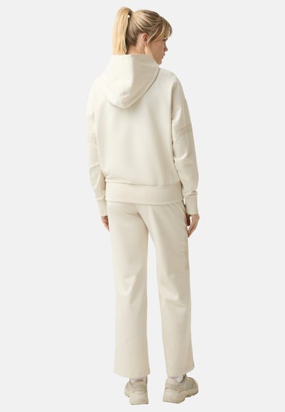 Cremefarbener Hoodie und passende Hose aus weichem Material, mit lässigem Schnitt, gerippten Bündchen und Kapuze. Minimalistisches Design ohne sichtbare Logos.