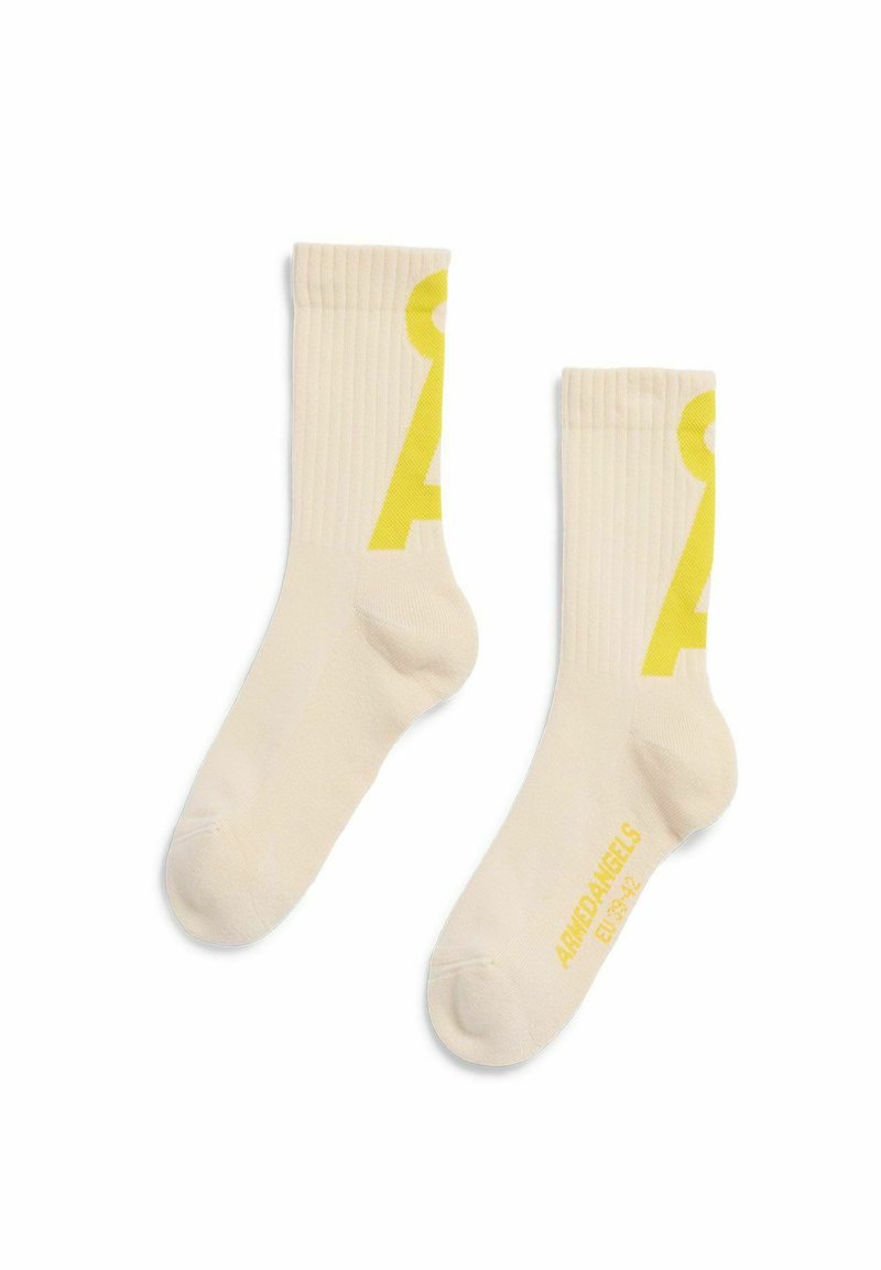 Cremefarbene Sportsocken mit Rippbündchen, versehen mit einer großen gelben Schlüssel-Grafik und dem Schriftzug "ARMEDANGELS" auf der Sohle.