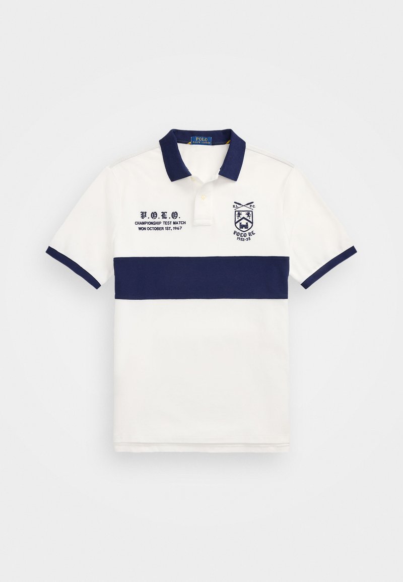 Valge polo särk, millel on tumesinised horisontaalsed triibud, brodeeritud logo ja tekstiline detail vasakul küljel; klassikaline krae ja lühikesed varrukad.