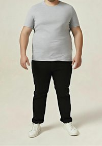 Camiseta gris de manga corta combinada con vaqueros negros y zapatillas blancas, con un diseño sencillo y ajuste ceñido. Se aprecia una textura de tela suave.