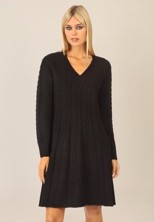 Abito nero lavorato a maglia con scollatura a V, motivo a trecce, maniche lunghe e silhouette a trapezio. Tessuto morbido e design di lunghezza media.