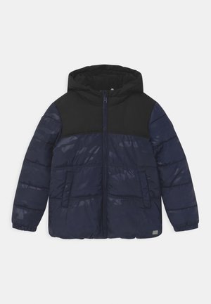 Veste matelassée bleu marine avec capuche et panneau supérieur noirs, dotée d'une fermeture éclair à l'avant, de deux poches latérales et de poignets élastiques.