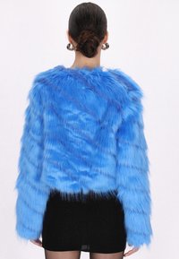 Faux fur-jacka i livlig blå färg med en tovig textur, kort design och långa ärmar. Har en rak nederkant och mjuk finish.
