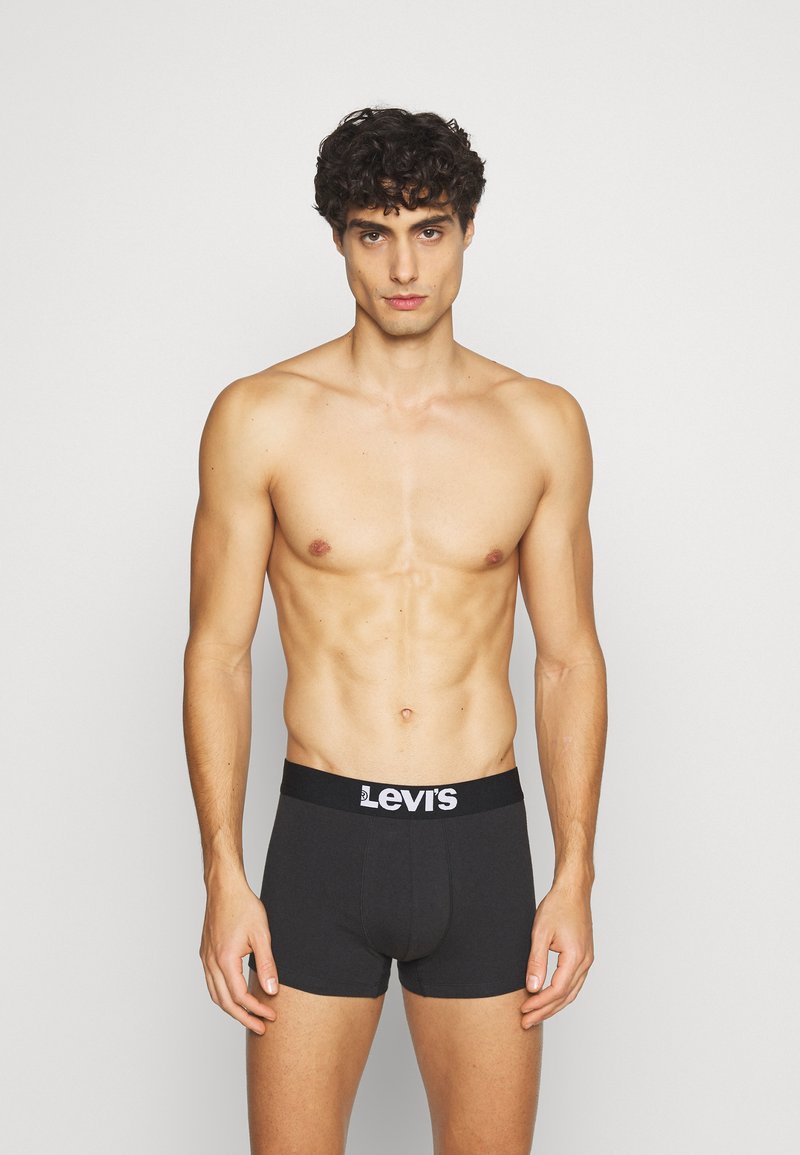Schwarze Baumwoll-Boxershorts mit breitem elastischem Bund, der das Levi's-Logo in Weiß trägt. Glatte Textur, figurbetonter Schnitt, Länge bis zur Mitte des Oberschenkels.