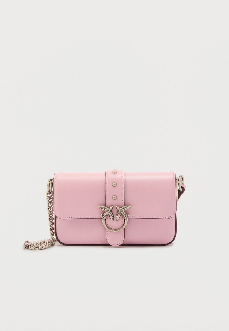 Ροζ δερμάτινη τσάντα ώμου με αλυσίδα ασημί, μπροστινό καπάκι και κούμπωμα διακοσμημένο με δύο πουλιά σε κυκλικό δαχτυλίδι.