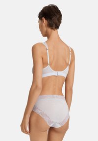 Svetle šedá podprsenka a kalhotky ve měkké tkanině, s krajkovým lemem kolem pasu. Nastavitelné ramínka se zapínáním na háček na zadní straně.
