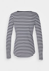 Långärmad topp med ett marinblått och vitt randigt mönster, rundad halsringning och figurnära passform, tillverkad av mjukt, lätt tyg.