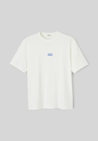 T-shirt blanc à manches courtes et col rond avec un petit texte bleu « JOUEUR DU DIMANCHE » centré sur la poitrine, suspendu à plat sur fond gris.