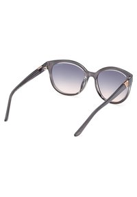 Gafas de sol de gran tamaño con montura de plástico gris y lentes que van de gris oscuro a gris claro. Presentan un pequeño acento dorado en la bisagra.