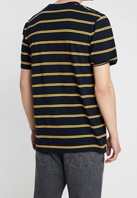 Camiseta de rayas marineras con rayas horizontales amarillas, de manga corta y cuello redondo, hecha de suave tela de algodón.