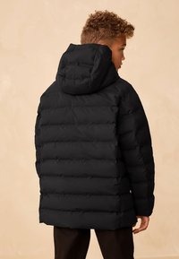 Schwarze Steppjacke mit Kapuze, mit horizontalen Nähten und weiter Passform. Weiches, isoliertes Material sorgt für Wärme und Schutz.