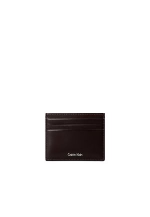 Portacarte in pelle marrone scuro con sei fessure orizzontali per carte e logo "Calvin Klein" inciso in argento al centro in basso.