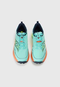 Pár tyrkysových běžeckých bot s oranžovými podrážkami a modro-černým vnitřkem, zobrazených zhora na bílém pozadí.