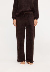 Braunes Fleece-Loungewear-Set mit locker sitzenden Hosen, elastischem Bund und Kordelzug, strukturiertem Material und entspannter Silhouette.