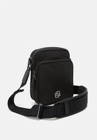 Sac bandoulière noir en nylon texturé. Présente un logo argenté, des compartiments à zip doubles et une large sangle réglable avec branding.