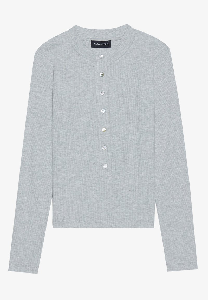 Cardigan lungo grigio chiaro a maniche lunghe con scollo rotondo, dotato di una patta con cinque bottoni rotondi e lucidi e un design aderente.