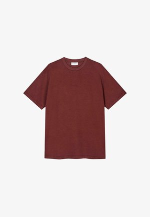 Camiseta de algodón burdeos con cuello redondo y mangas cortas. Presenta un sutil bordado del logo en la parte frontal. Textura suave.