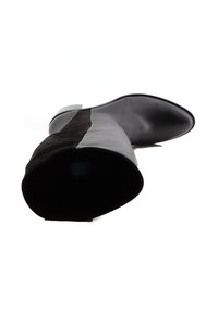 Bota de cuero negra y gris hasta la rodilla con texturas de cuero liso y suave ante, con punta afilada y tacón delgado. Diseño minimalista.