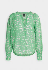 Blouse verte avec imprimé abstrait rose pâle, manches longues bouffantes et encolure en V sans col.