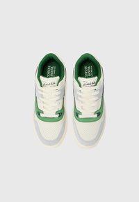Hvide og grønne sneakers med et mesh-design, grå accenter, perforeret overflade og hvide snørebånd. Har branding på tungen og siden.
