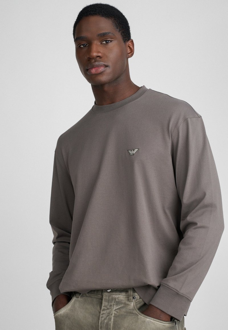 Halliksin halli pika varrukaga t-särk ümmarguse kaelusega ja väike tikitud logo rinnal. Pehme kangas ja lõdva istuvusega, detailne õmblus varrukaotsadel.