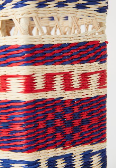 Woven basket o cylindrycznym kształcie, z czerwonymi i niebieskimi paskami przerywanymi naturalnymi odcieniami, podkreślającymi teksturowany wzór.