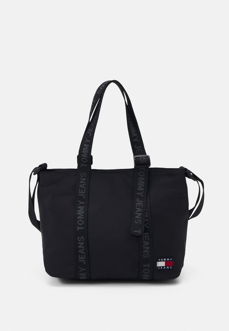 Czarna torba na ramię wykonana z trwałego materiału, z podwójnymi uchwytami u góry oraz paskami z logo "TOMMY JEANS". Zawiera małą naszywkę z logo z przodu.