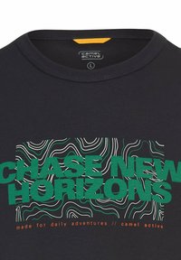 Schwarzes T-Shirt mit grüner Aufschrift "NEUE HORIZONTE JAGEN" über weißen und grünen topografischen Linien und kleiner oranger Schrift "gemacht für tägliche Abenteuer."