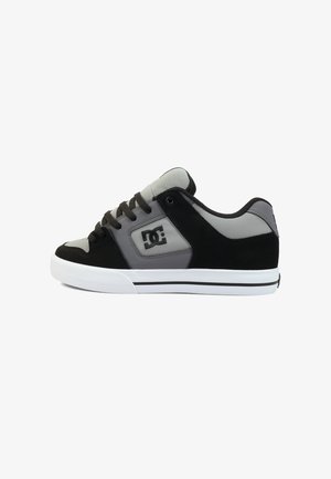 Niskie czarno-szare buty do deskorolki DC z białą podeszwą, czarnymi sznurowadłami i siateczkowym językiem, widoczne z boku na białym tle.