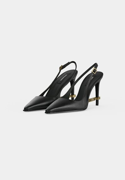Pair of black leather pointed-toe slingback high heels with gold buckle and decorative gold bar detail on the stiletto heels.