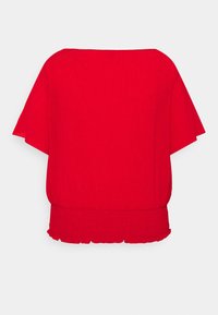 Rød, letvægts top med løs pasform, korte ærmer og en flæse på kanten. Struktureret stof tilføjer visuel interesse. Bagfra set.