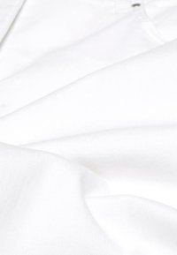 Witte stof met een gladde, zachte textuur, voorzien van subtiele plooien. Close-upweergave benadrukt een schoon ontwerp en minimale details.