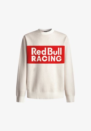 Biały sweter z długim rękawem, z czerwonym prostokątnym logo z napisem "Red Bull RACING" umieszczonym na środku klatki piersiowej.