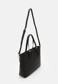 Bolso tote de cuero negro con asas dobles y una correa de hombro desmontable. Presenta una textura suave y detalles en metal dorado.