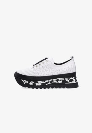 Hvid slip-on sneaker med perforeret overdel, metalliske snørehuller og tyk sort sål med hvide blomsterprint.