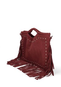 Bordeaux-suède tas met franjes, zilveren studs langs de randen, handvat aan de bovenkant en een open vak. Gelaagd uiterlijk en een zachte uitstraling.