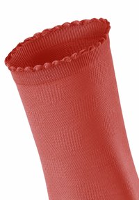 Chaussette rouge tricotée avec un bord supérieur ondulé, présentant un motif texturé subtil sur le corps et une finition lisse dans l'ensemble.