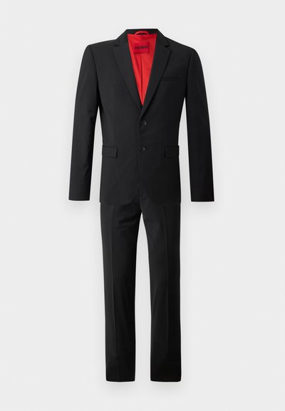 Costume noir avec une veste à bouton unique, deux boutons, revers crantés et un pantalon assorti. Doublure rouge et coupe ajustée.