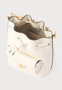Borsa a secchiello in pelle bianca con trama, bordatura smerlata sulla parte superiore, dettagli in metallo dorato e tasca frontale con chiusura magnetica.